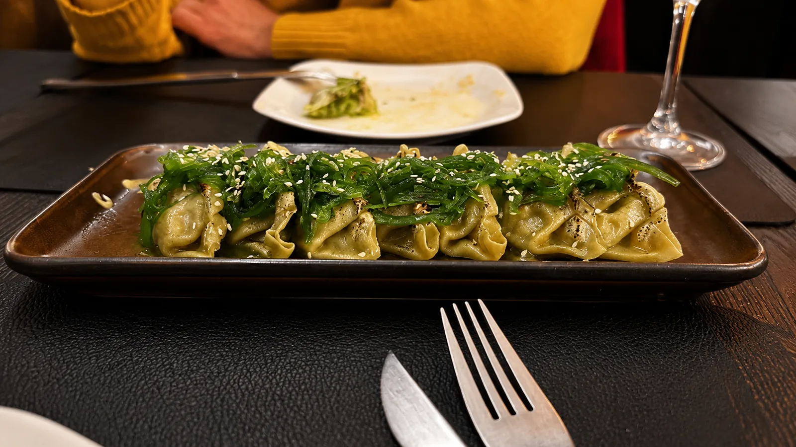 Safata de gyozas al centre de la taula del Síbaris, amb un comensal a punt de començar